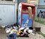 Titel:  Beschreibung: Kleidung und sonstiger Müll liegen rund um den Altkleider-Container verteilt.